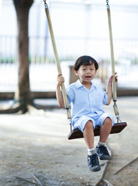 Cute boy on swing in playground