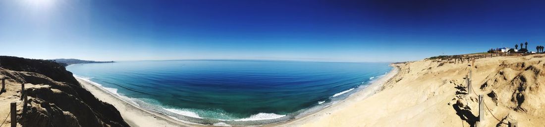 Panoramic view of sea against clear blue sky