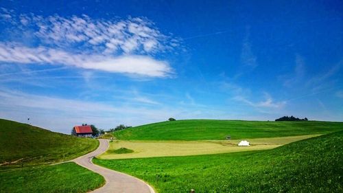 Scenic view of grassy field against cloudy sky