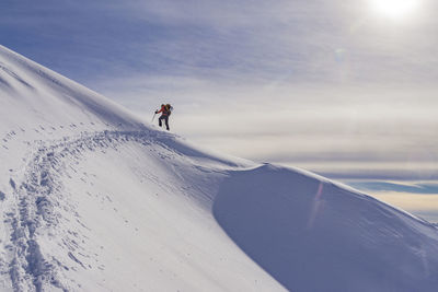 Man on snowcapped mountain against sky