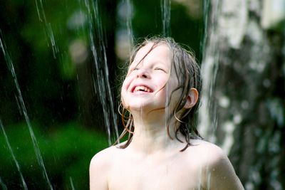 Smiling shirtless boy with fountain