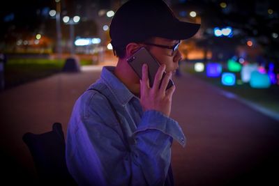 Portrait of woman using mobile phone at night