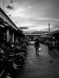 Rear view of people walking on street in city