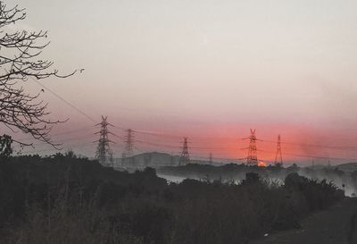 Electricity pylon against sky during sunset