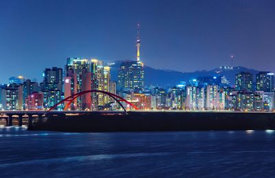 Illuminated buildings in city against sky at night