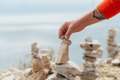 Midsection of man holding rock at beach