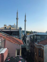 Mosque and buildings against clear sky