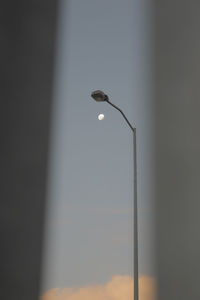 Low angle view of illuminated street light against wall