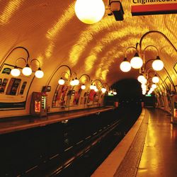 Illuminated railroad station platform at night