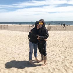 Full length of friends standing on beach