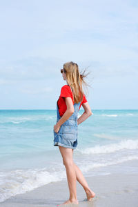 Rear view of woman standing at beach