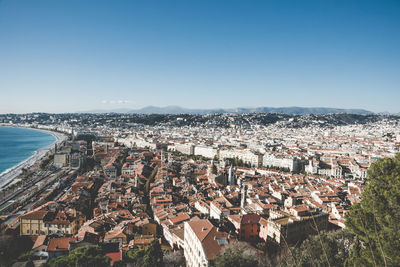High angle view of townscape by sea against clear sky
