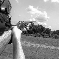 Close-up of man sitting against sky