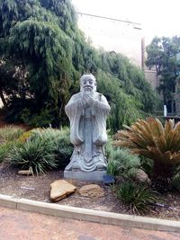 Statue in park against sky