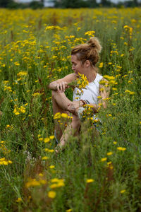 Portrait of young woman sitting on field