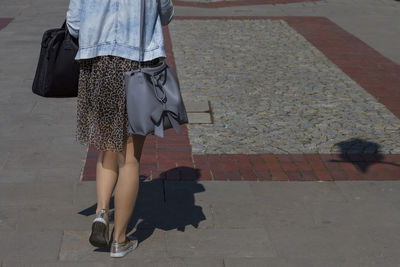 Low section of woman walking on footpath