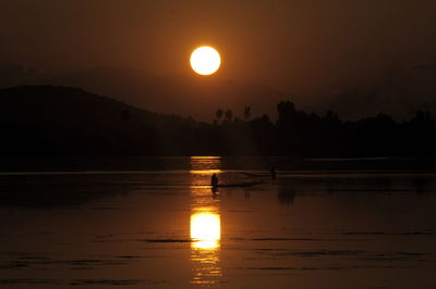 Scenic view of lake against sky during sunset