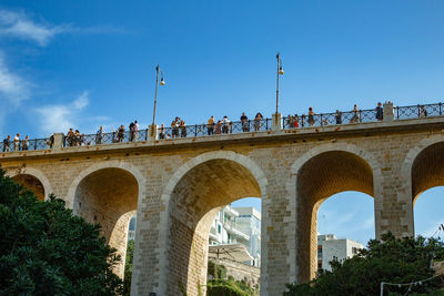 Arch bridge over river against sky