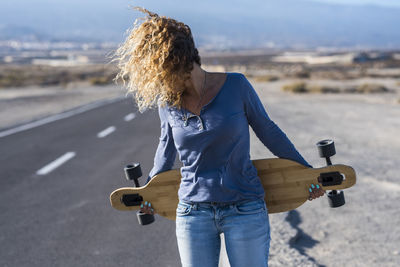 Side view of young woman exercising on road