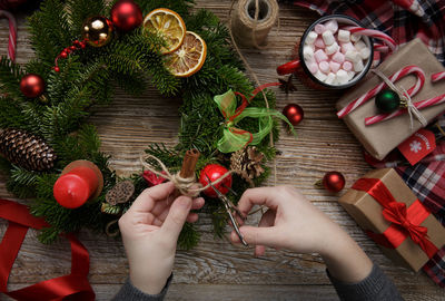 Cropped hand of woman holding christmas tree