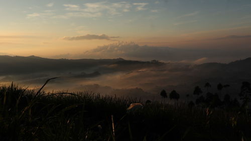 Scenic view of silhouette mountains against sky during sunset