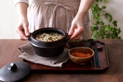 Midsection of woman holding food on table