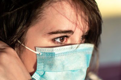 Close-up of beautiful woman wearing flu mask outdoors