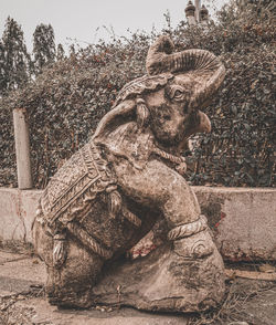 Close-up of old statue against trees