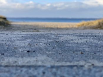 Surface level of sand on beach against sky