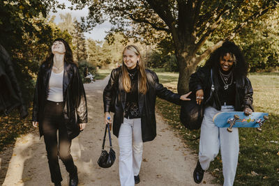 Cheerful female friends walking together in park