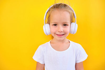 Portrait of young woman against yellow background