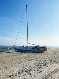 Sailboat on beach against sky