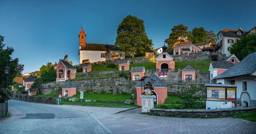 Houses by buildings against sky in city