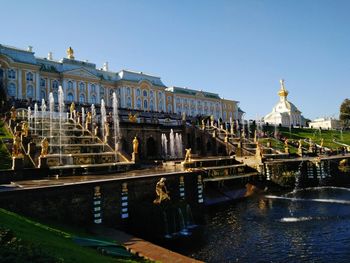 Fountain and buildings by river in city