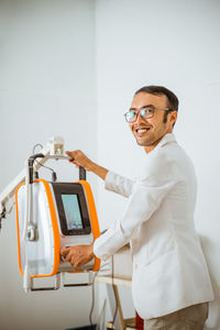 Portrait of young man standing against white background