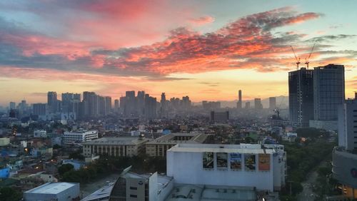 View of cityscape against cloudy sky