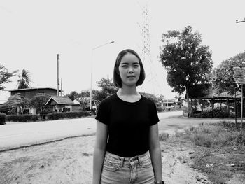 Portrait of teenage girl standing against sky