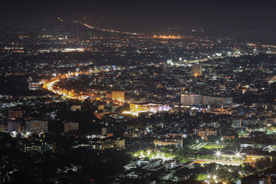 High angle view of illuminated cityscape against sky at night