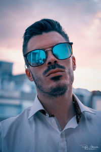 Portrait of man wearing sunglasses against sky during sunset