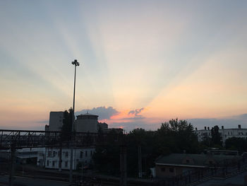 Street and buildings against sky during sunset