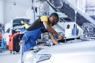 Side view of man holding car