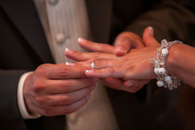 Midsection of bridegroom holding hands