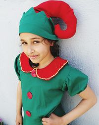 Portrait of girl in costume standing against wall