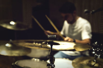 Close-up of man playing drum in darkroom
