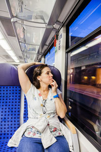 Full length of woman sitting in train