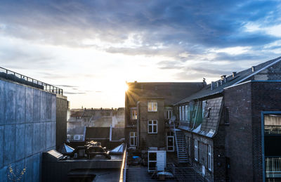 Buildings in town against sky during sunset