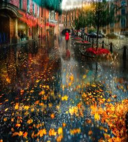 Reflection of illuminated buildings in puddle