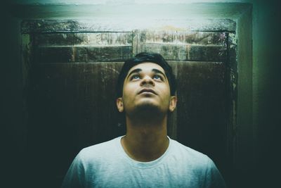 Portrait of young man looking away at home