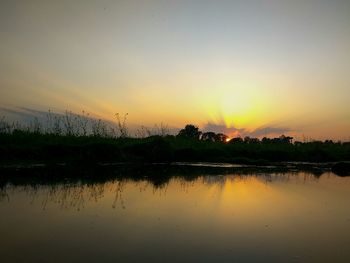 Scenic view of lake against orange sky