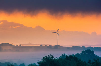 Silhouette windmill against sky during sunset